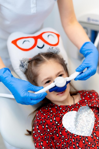 Trattamento dentale orale professionale per bambini. Bambino piccolo che esamina lo specchio nell'armadietto del dentista.