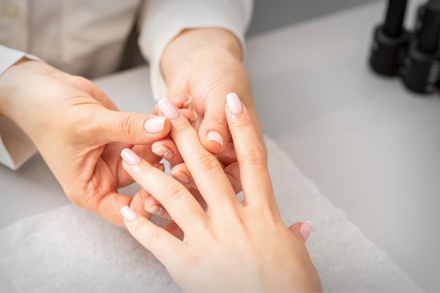 Trattamento manicure presso la spa di bellezza. Una mano di una donna che riceve un massaggio con le dita con olio in un salone di bellezza.