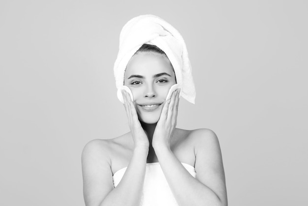 Trattamento viso cosmetologia bellezza e spa ragazza applicare crema per la cura della pelle sul viso donna avvolgere asciugamano su lui