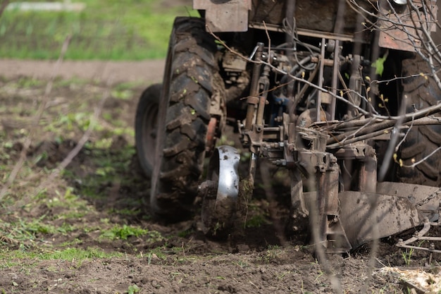 trattore agricolo con aratro ara il campo e si prepara per la semina.