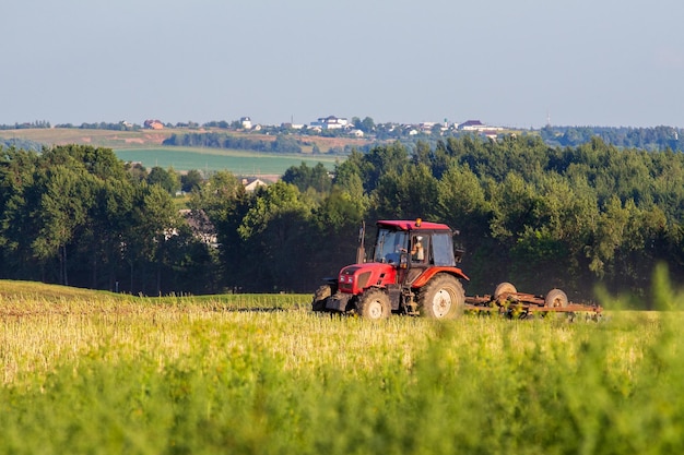 Trattore che ara un campo in una giornata limpida vista dell'orizzonte