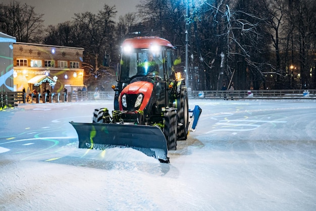 Trattore che pulisce il ghiaccio d'ora in poi pista di pattinaggio decorata per natale