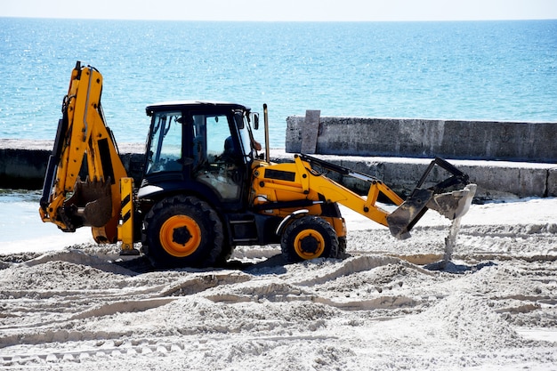 Trattore e sabbia. Lavori di riparazione in spiaggia.