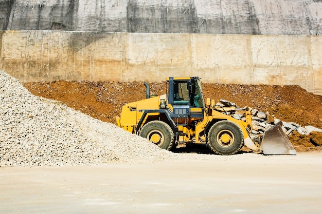 trattore funzionante giallo sullo sfondo della roccia