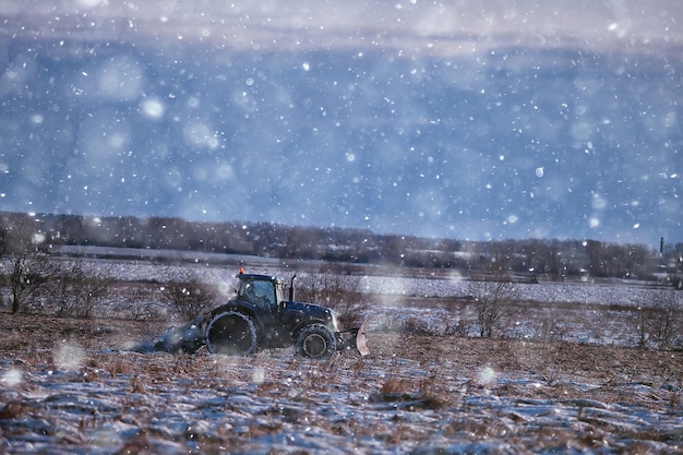 trattore nel campo seminativo inverno paesaggio agroalimentare lavoro stagionale in un campo innevato