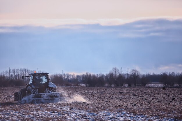 trattore nel campo seminativo inverno paesaggio agroalimentare lavoro stagionale in un campo innevato