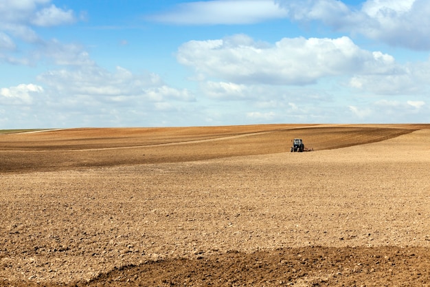 Trattore nel campo un trattore che ara un campo situato nel terreno durante la semina