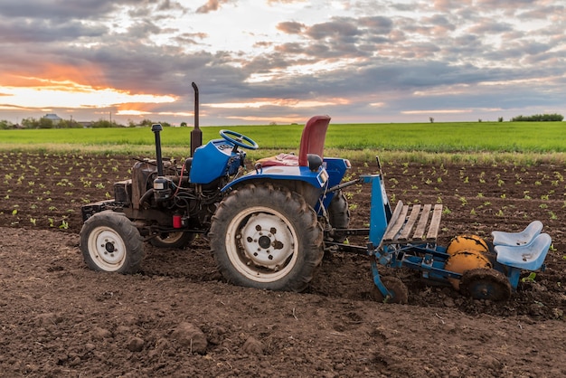 Trattore nel mezzo di un campo al tramonto paesaggio rurale