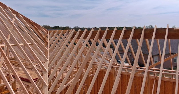 Travatura reticolare del tetto in legno la nuova casa su una vista sullo sfondo del cielo limpido in cantiere