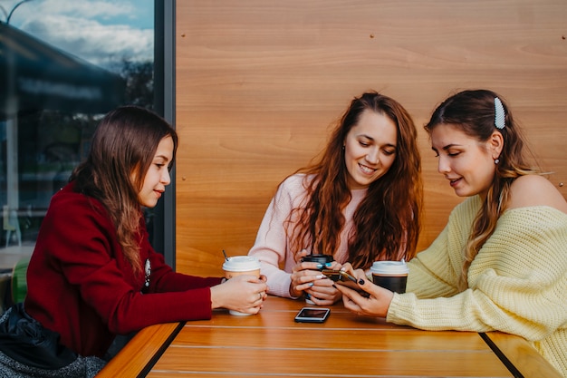 Tre amiche che chiacchierano in un bar per una tazza di caffè