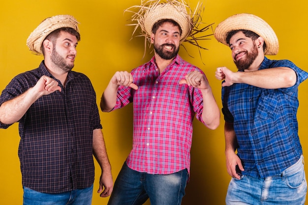 Tre amiche che indossano gli abiti tipici della Festa Junina Pollice in giù delusione