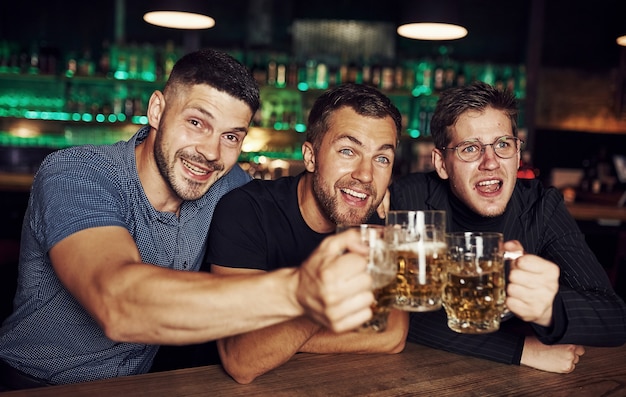 Tre appassionati di sport in un bar a guardare il calcio