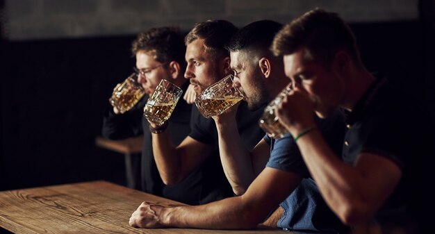 Tre appassionati di sport in un bar a guardare il calcio