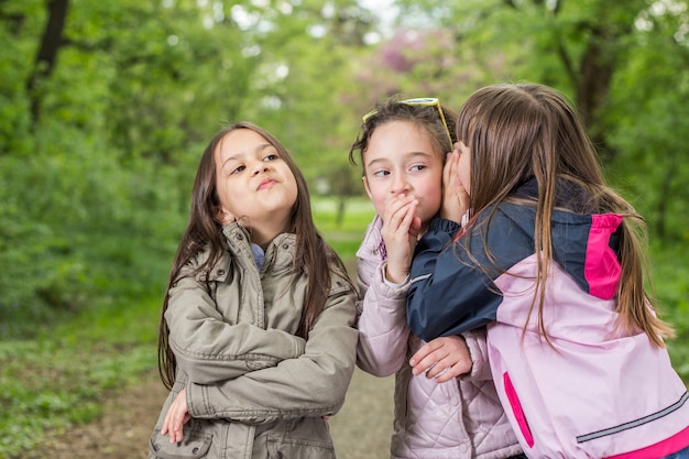 Tre bambine che parlano nel parco