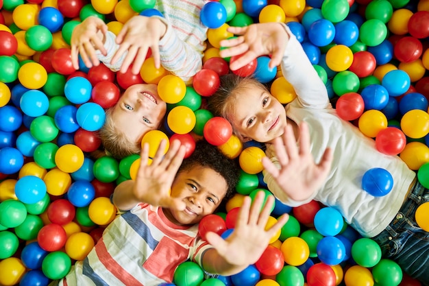 Tre bambini che giocano nel ballpit