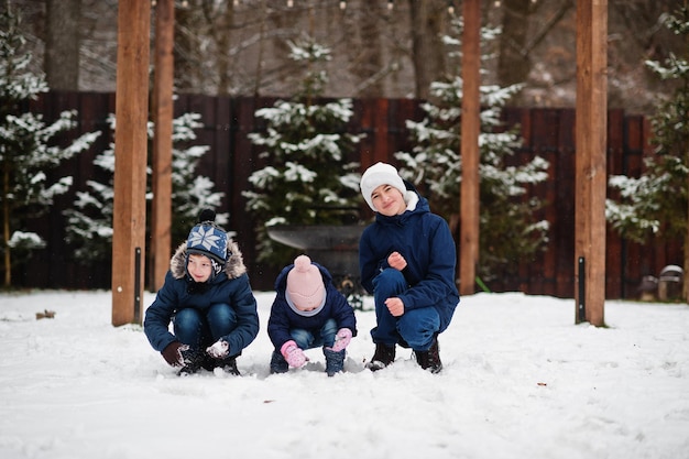 Tre bambini che giocano nel giorno d'inverno Fratelli con la sorella più giovane