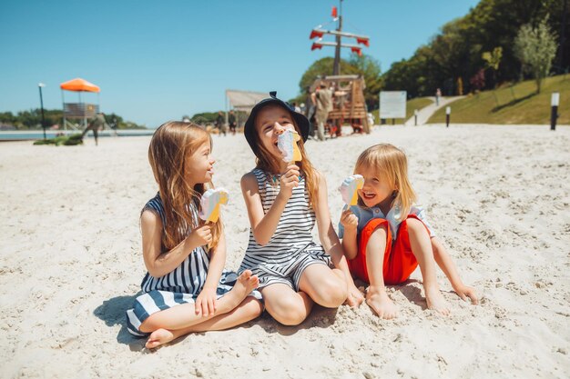 Tre bambini mangiano il gelato in spiaggia un bambino con sindrome di down conduce una vita normale