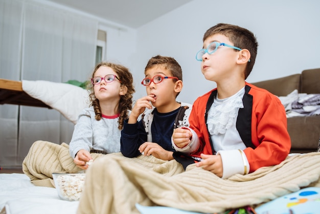 Tre bambini piccoli che giocano felici insieme nell'appartamento