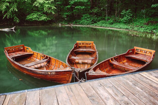 tre barche rosse di legno in un lago con acqua verde