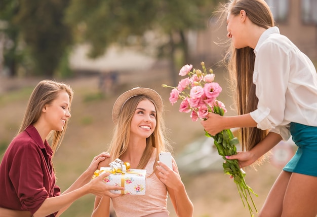 Tre belle giovani donne con fiori all'aperto