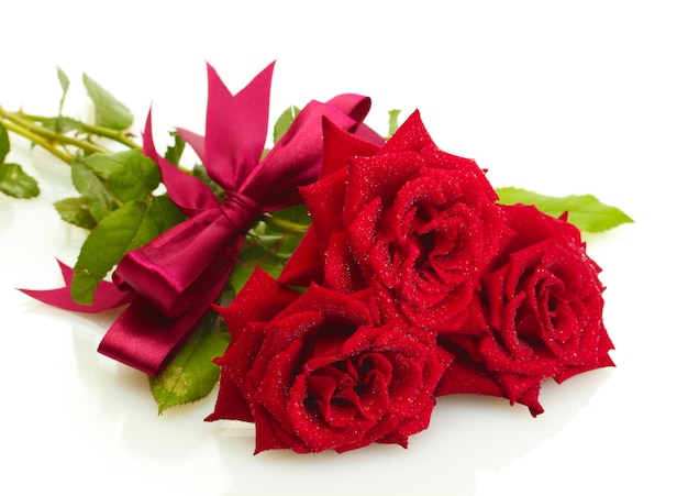 Tre belle rose rosse con gocce isolate su bianco