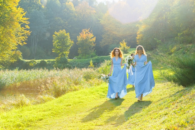 Tre bellissime damigelle nel parco il giorno del matrimonio