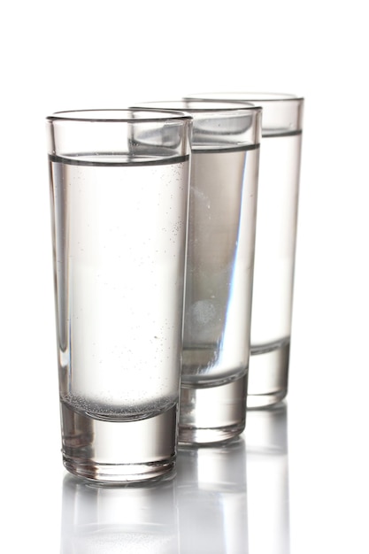 Tre bicchieri di vodka isolati su bianco