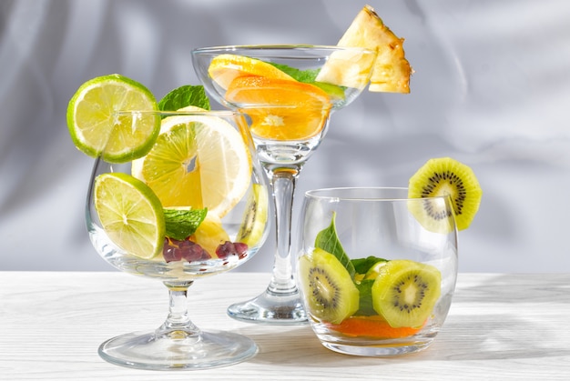 Tre bicchieri per cocktail con frutta e bacche senza liquido