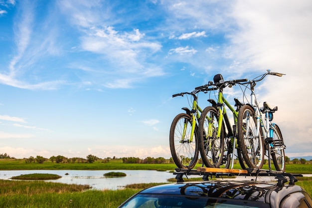 Tre biciclette su portapacchi in riva al fiume