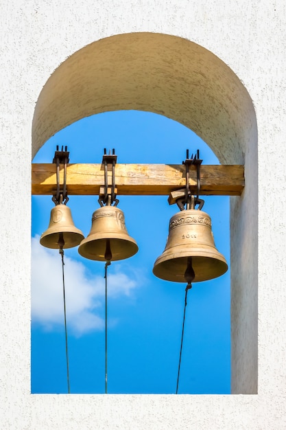 Tre campane sul campanile della chiesa ortodossa sullo sfondo del cielo blu in una giornata di sole