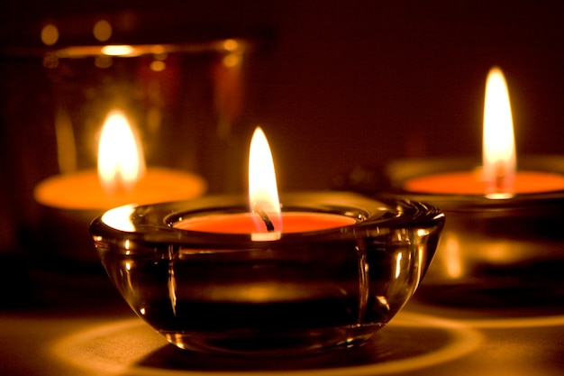 Tre candele fiammeggianti nel primo piano scuro