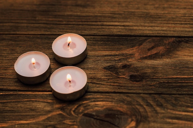 Tre candele galleggianti di paraffina su un tavolo di legno