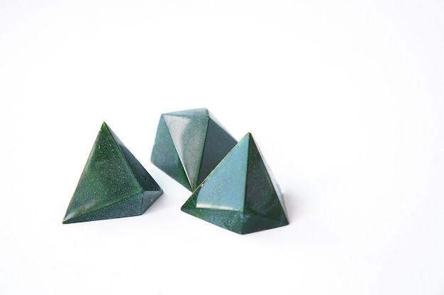 Tre cioccolatini di colore verde e design geometrico di caramelle triangolari