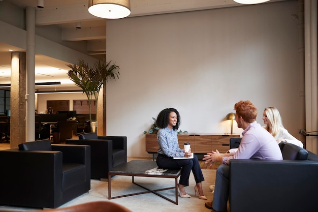 Tre colleghi a una riunione di lavoro informale in un'area lounge