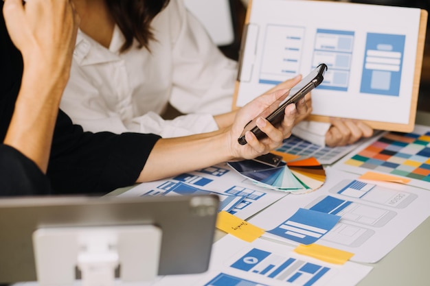 Tre colleghi che discutono di dati di lavoro e laptop tablet con il progetto architettonico in cantiere alla scrivania in ufficio