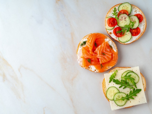 Tre deliziosi panini aperti con salmone, pomodori, cetriolo