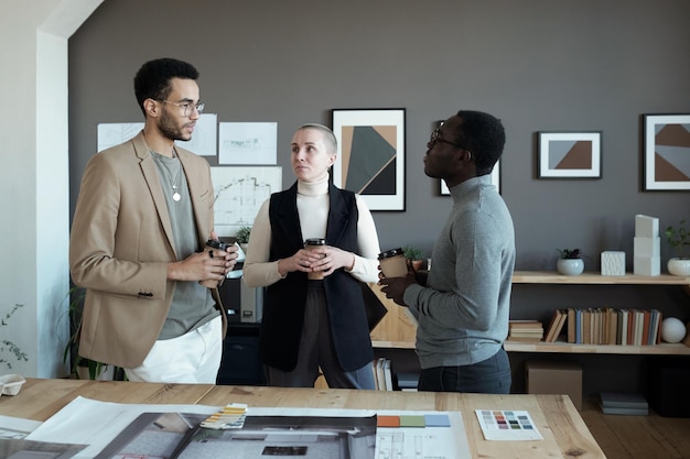 Tre designer creativi che bevono un caffè in pausa