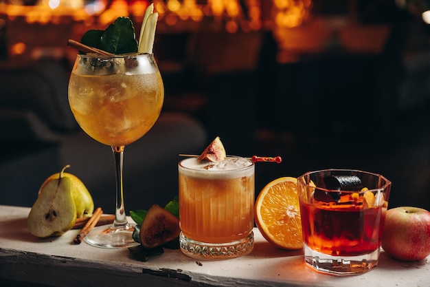 Tre diversi bellissimi cocktail in colori caldi su un cocktail di sfondo floreale