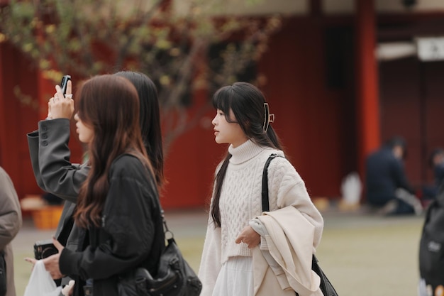 tre donne che camminano in un cortile con una che indossa una sciarpa