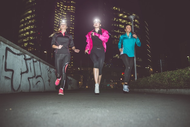 Tre donne che corrono di notte nel centro della città