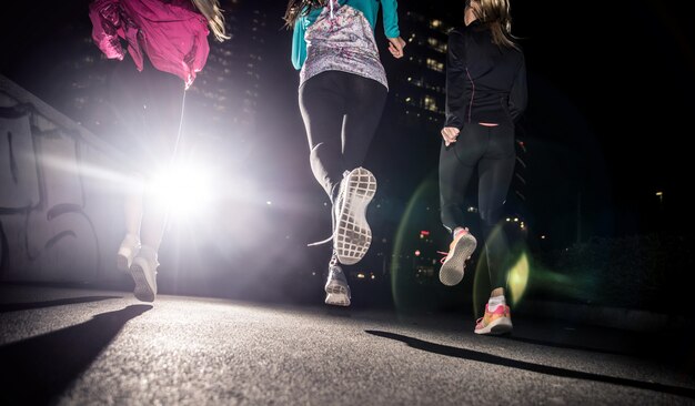 Tre donne che corrono di notte nel centro della città