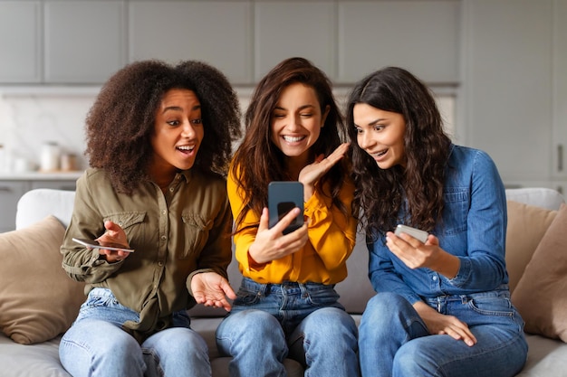 Tre donne che reagiscono ai contenuti sullo smartphone