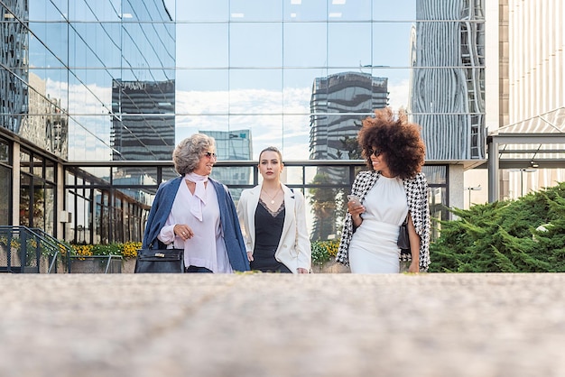 Tre donne d'affari che escono dal lavoro parlano tra loro