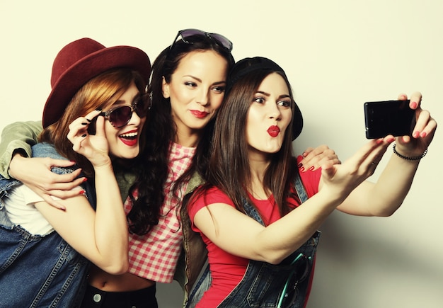 Tre eleganti ragazze hipster sexy migliori amiche che si fanno selfie con il cellulare