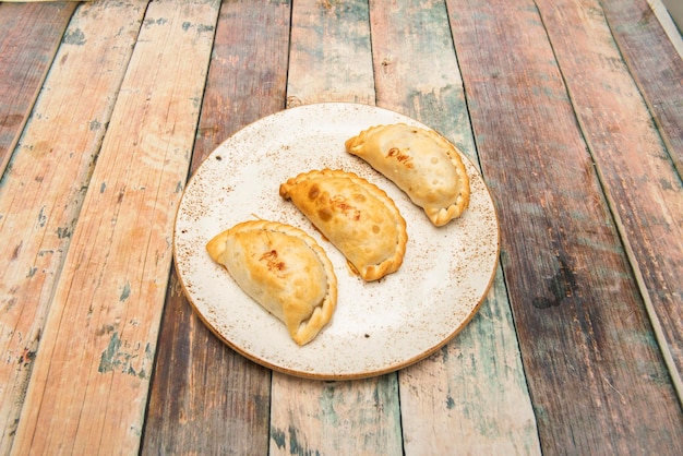 Tre empanadas di pollo argentino su un piatto bianco