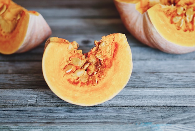 Tre fette di zucca sul tavolo di legno grigio