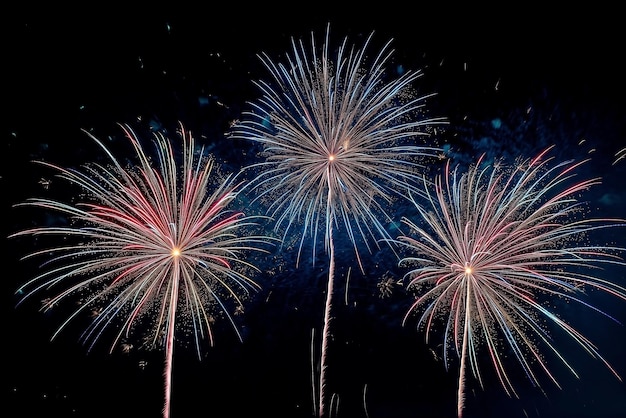 Tre fuochi d'artificio colorati piccoli nella posizione centrale di uno sfondo nero