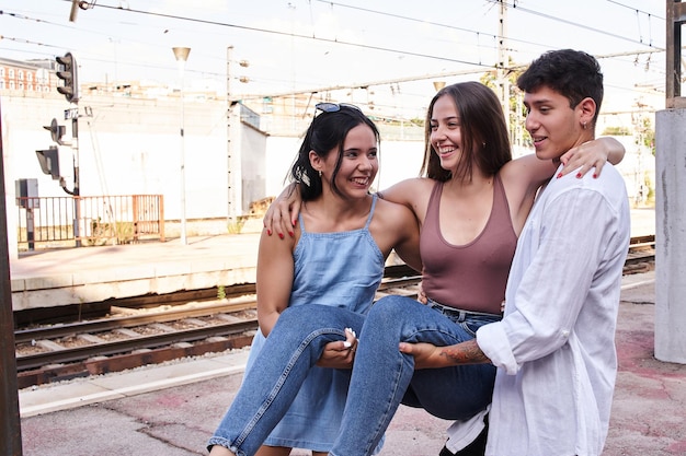 Tre giovani amici si divertono con un gruppo di millennial che portano in braccio una giovane ragazza caucasica