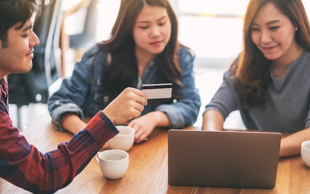 Tre giovani asiatici usano la carta di credito per acquistare e fare acquisti online