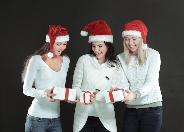 Tre giovani donne felici in costume di babbo natale con christma